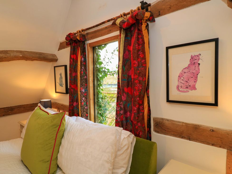 A bedroom with a bed and colorful curtains at The Linhay in Little Coxwell near Faringdon