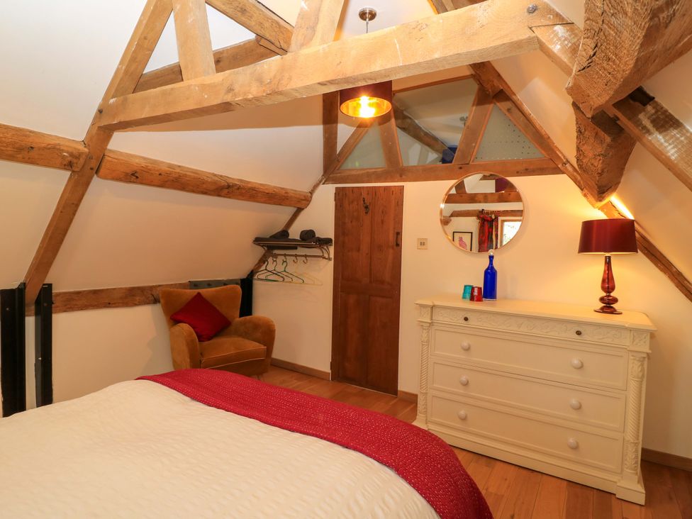 A bedroom with a bed and dressing table at The Linhay in Little Coxwell near Faringdon