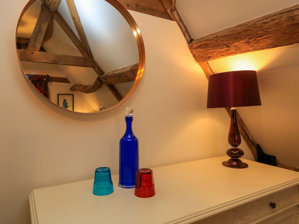 A living room with a mirror and decorative items at The Linhay Little Coxwell near Faringdon