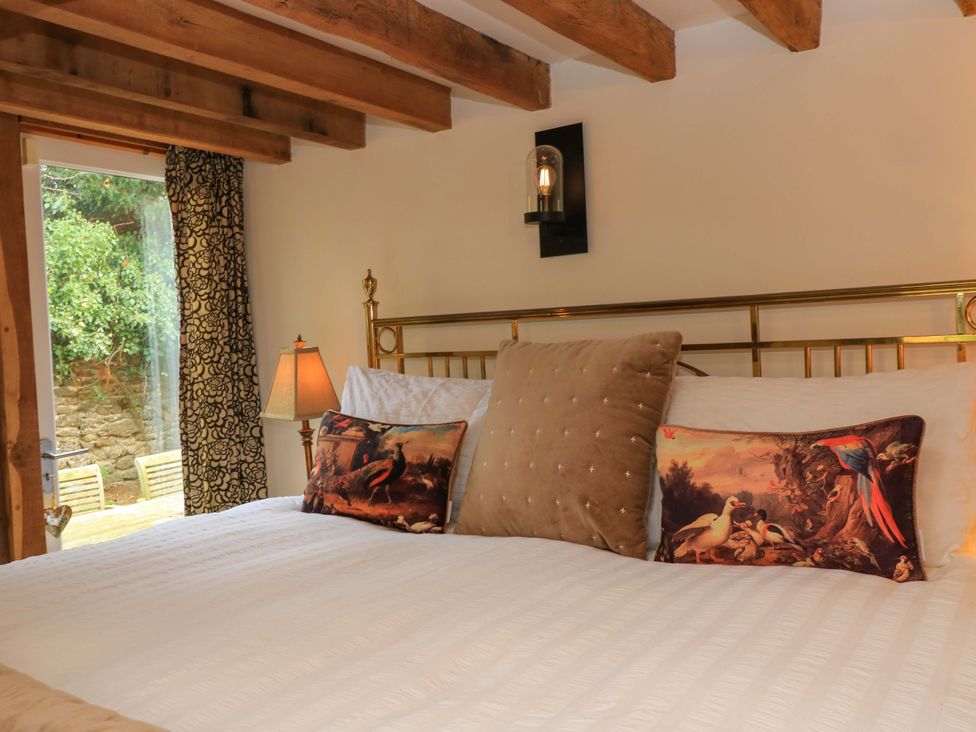 A bedroom with a bed and pillows at The Linhay in Little Coxwell near Faringdon