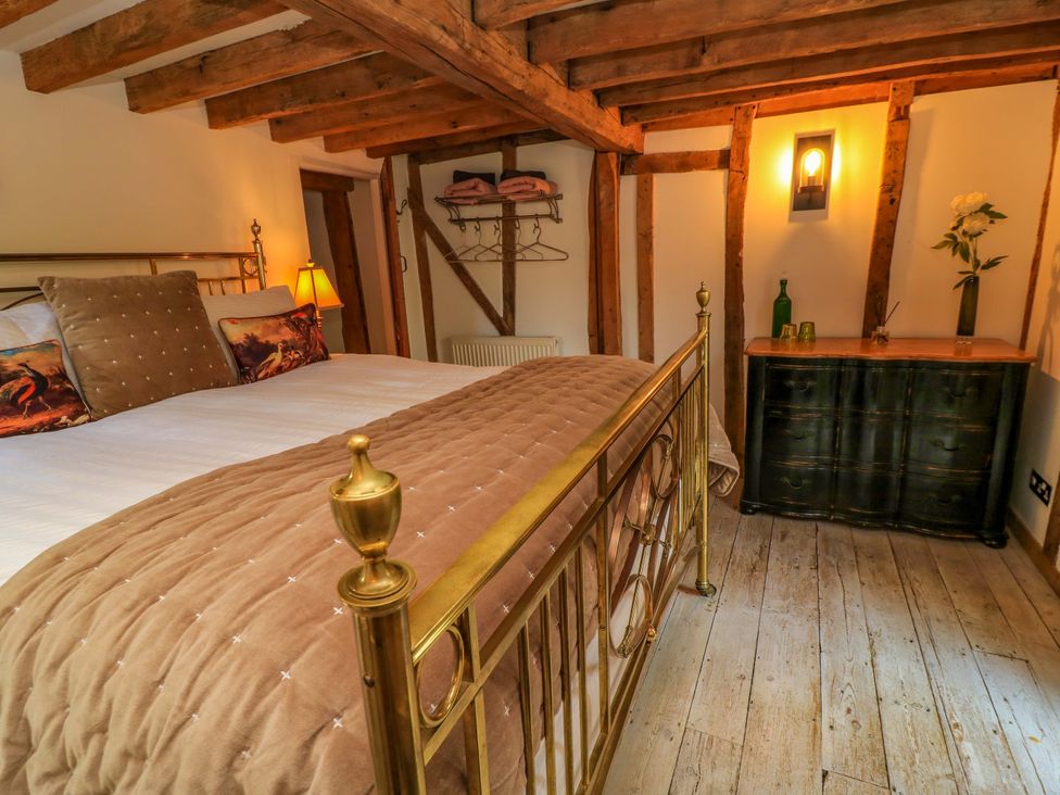 A bedroom with a bed and dresser at The Linhay in Little Coxwell near Faringdon