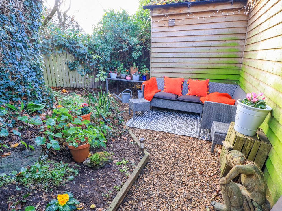 A garden with seating area and potted plants at The Linhay in Little Coxwell near Faringdon