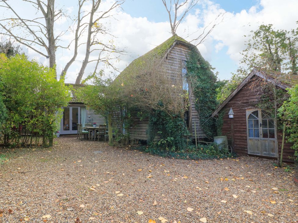 An outdoor area with a gravel driveway and trees at The Linhay in Little Coxwell near Faringdon