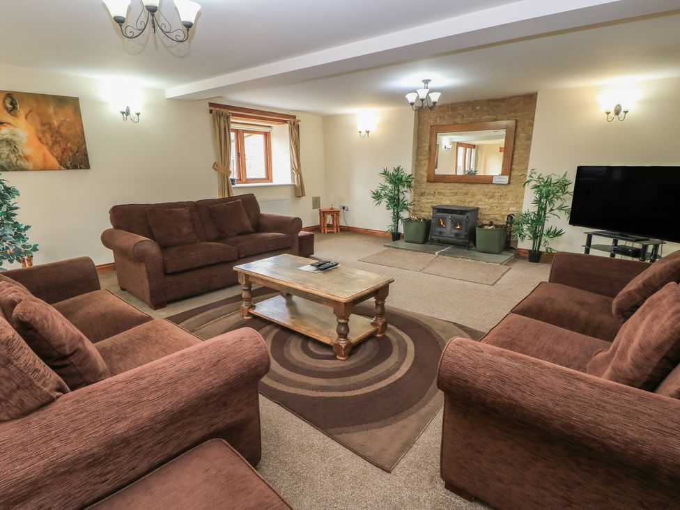 A living room with a fireplace and seating at Tithe Barn, Lyneham