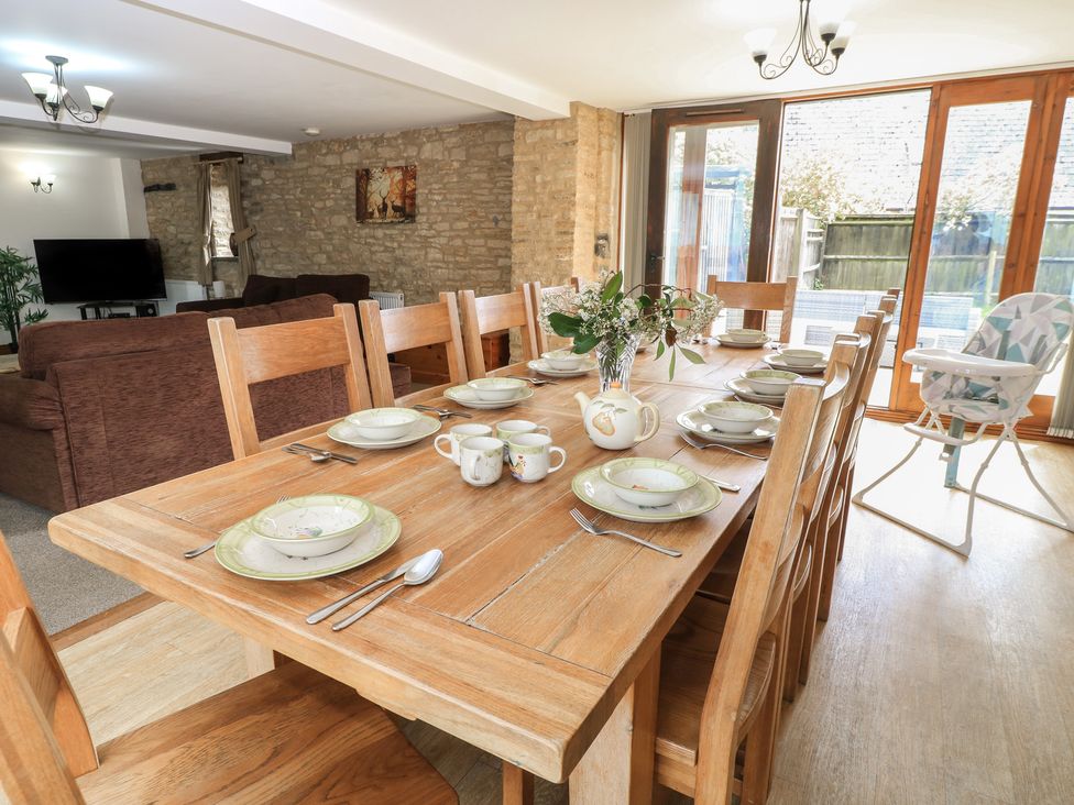 A dining room with a large table set for meals at Tithe Barn, Lyneham