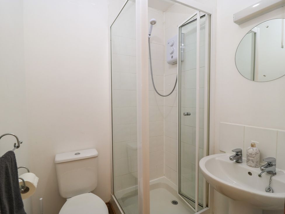 A bathroom featuring a shower, toilet, and wash basin at Tithe Barn, Lyneham