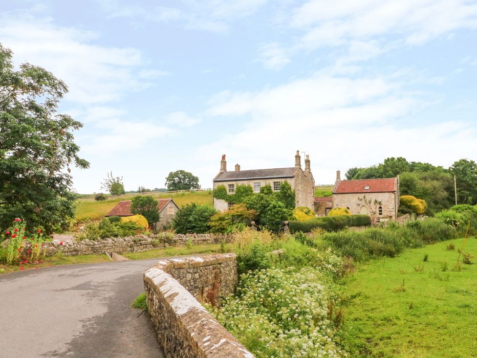 A house and garden viewed from a road near Cider Press Cottage in Priston Village, Bath