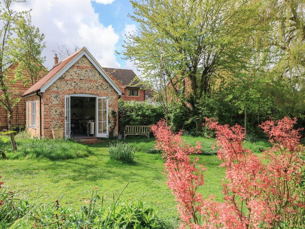 A brick building with open doors in a garden at Bridge Studio Near Broad Chalke