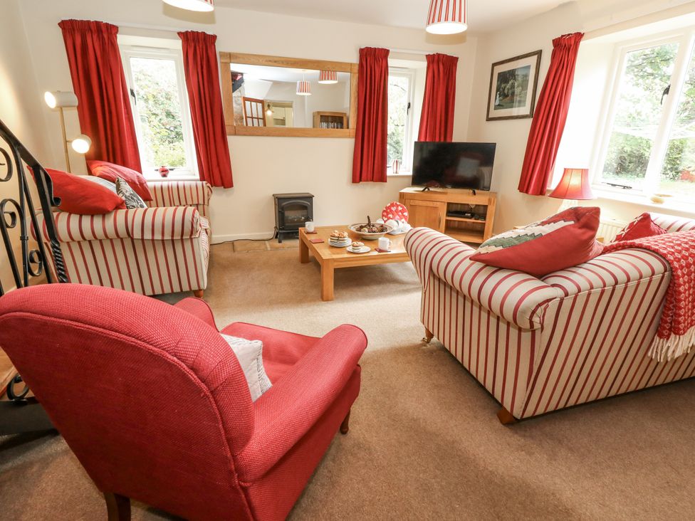 A living room with seating and a television at Droop Farm Cottage in Droop near Hazelbury Bryan