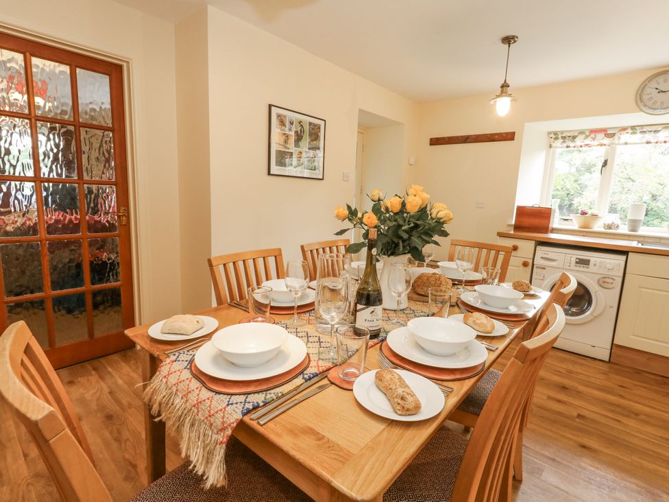 A dining room with a table set for a meal at Droop Farm Cottage Droop near Hazelbury Bryan