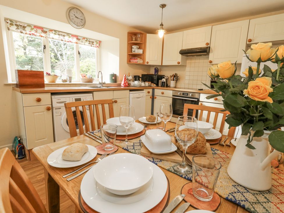 A kitchen with a dining table set for a meal at Droop Farm Cottage Droop near Hazelbury Bryan