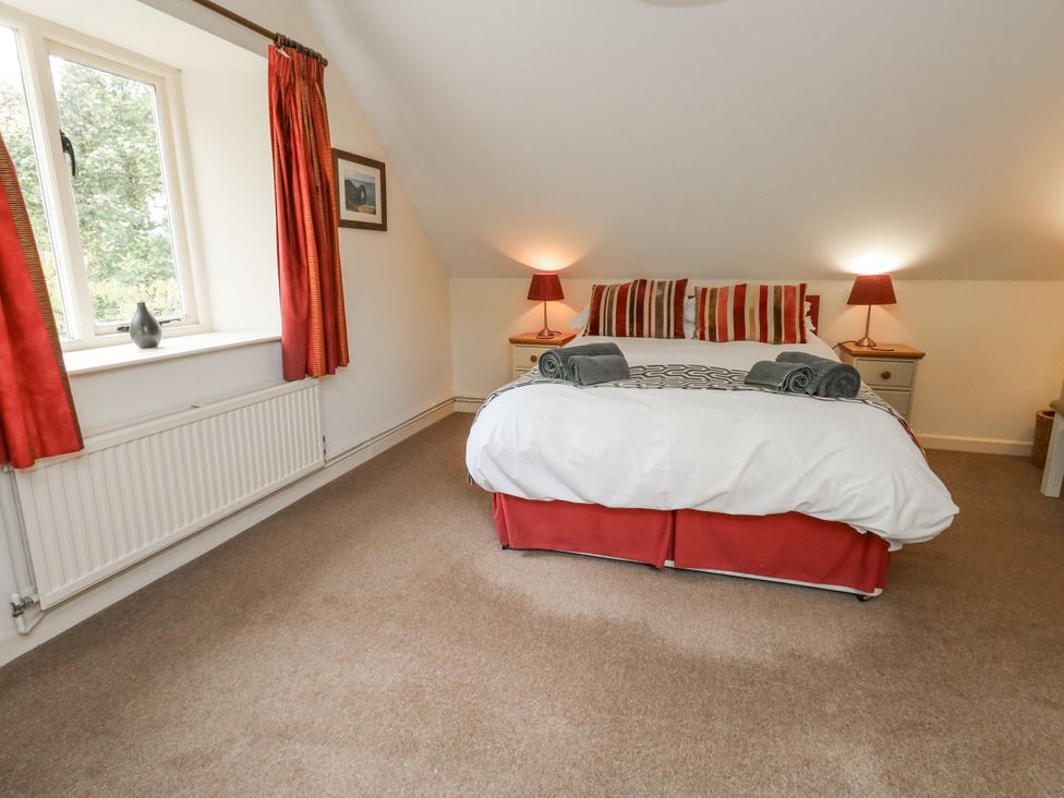 A bedroom with a bed and side tables at Droop Farm Cottage in Droop near Hazelbury Bryan