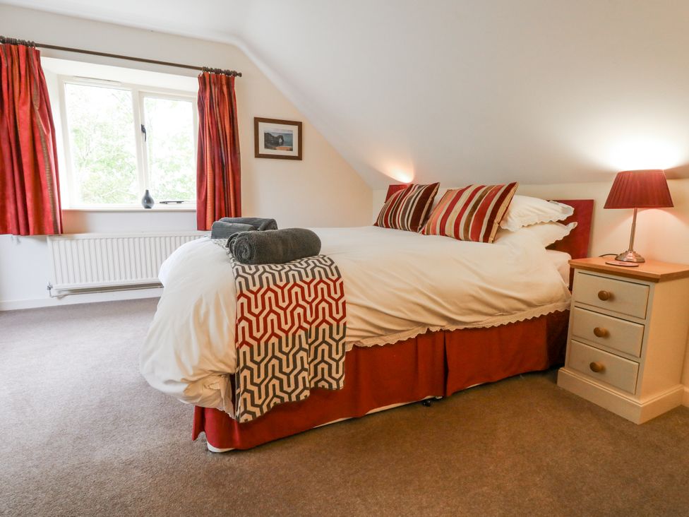A bedroom with a bed and window at Droop Farm Cottage in Droop near Hazelbury Bryan