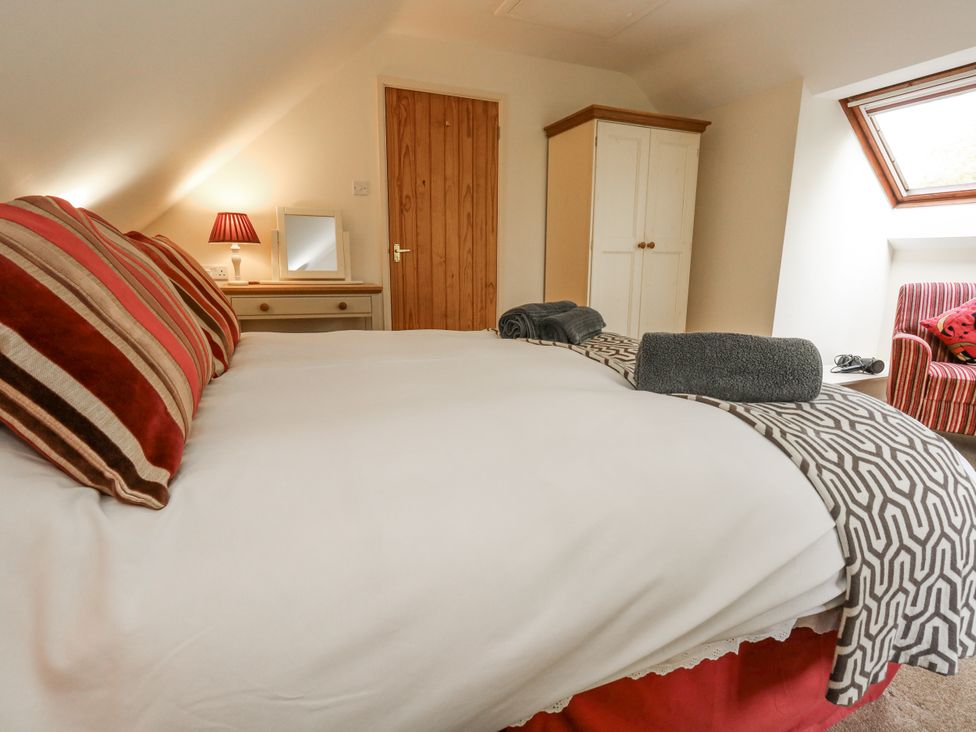 A bedroom with a bed and dressing table at Droop Farm Cottage Droop near Hazelbury Bryan