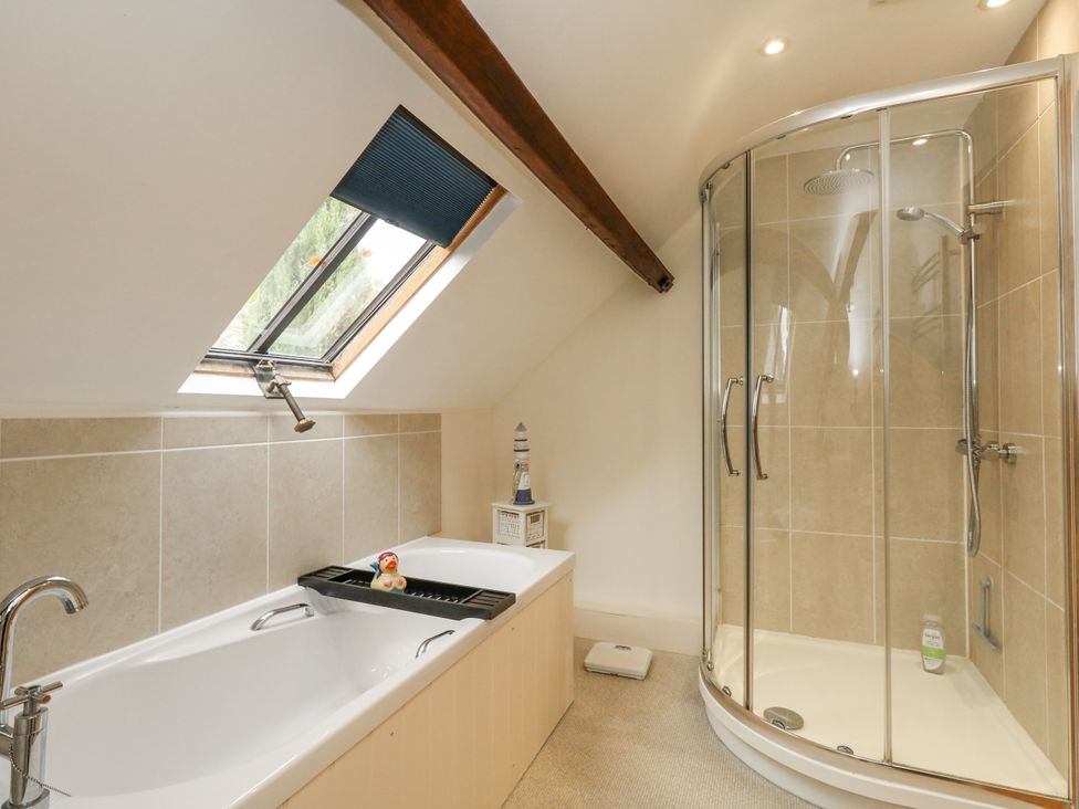 A bathroom with a bathtub and shower at Droop Farm Cottage in Droop near Hazelbury Bryan