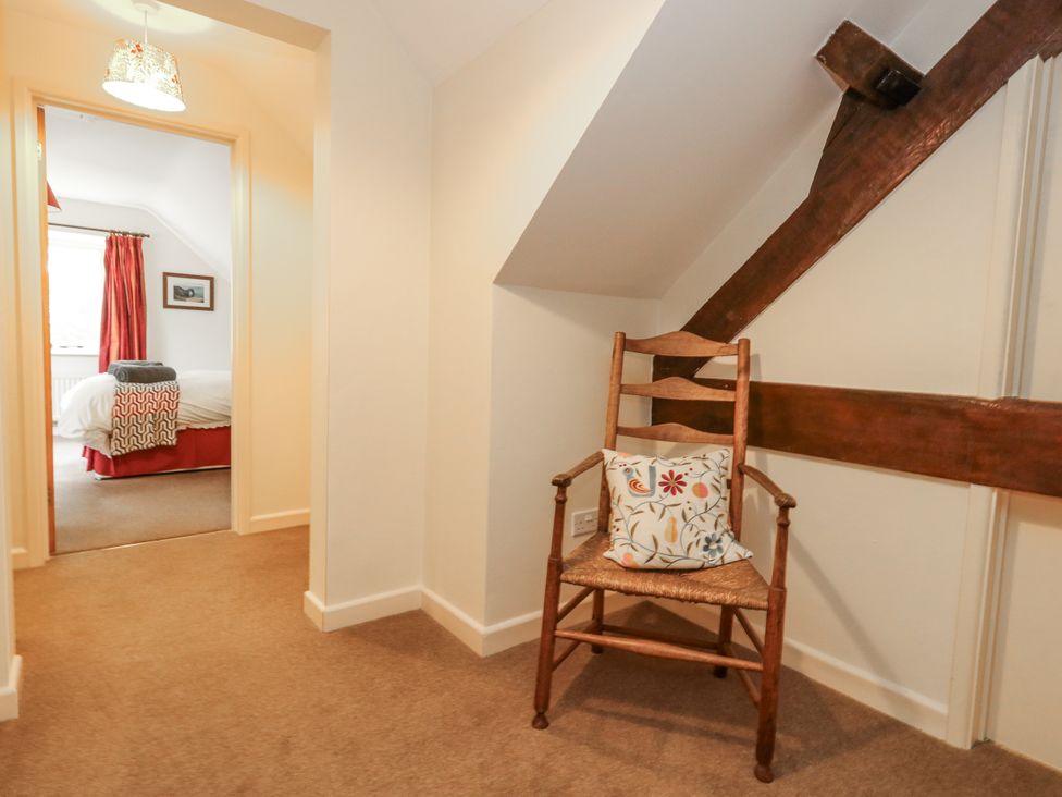 A hallway with a chair near a doorway at Droop Farm Cottage in Droop near Hazelbury Bryan