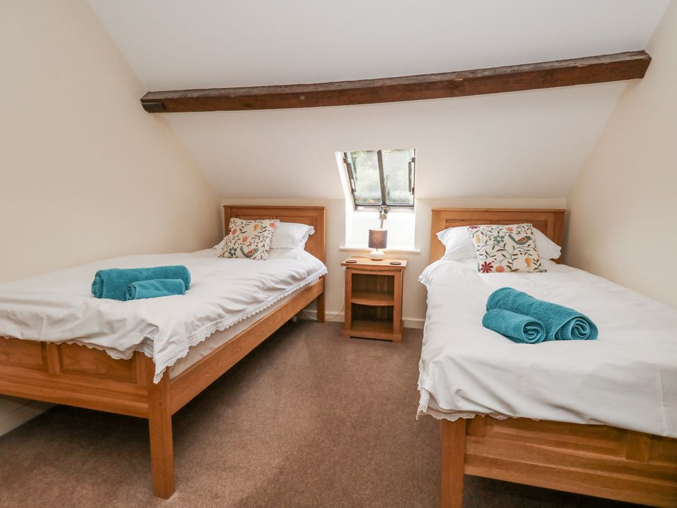 A bedroom with two single beds and a bedside table at Droop Farm Cottage Droop near Hazelbury Bryan