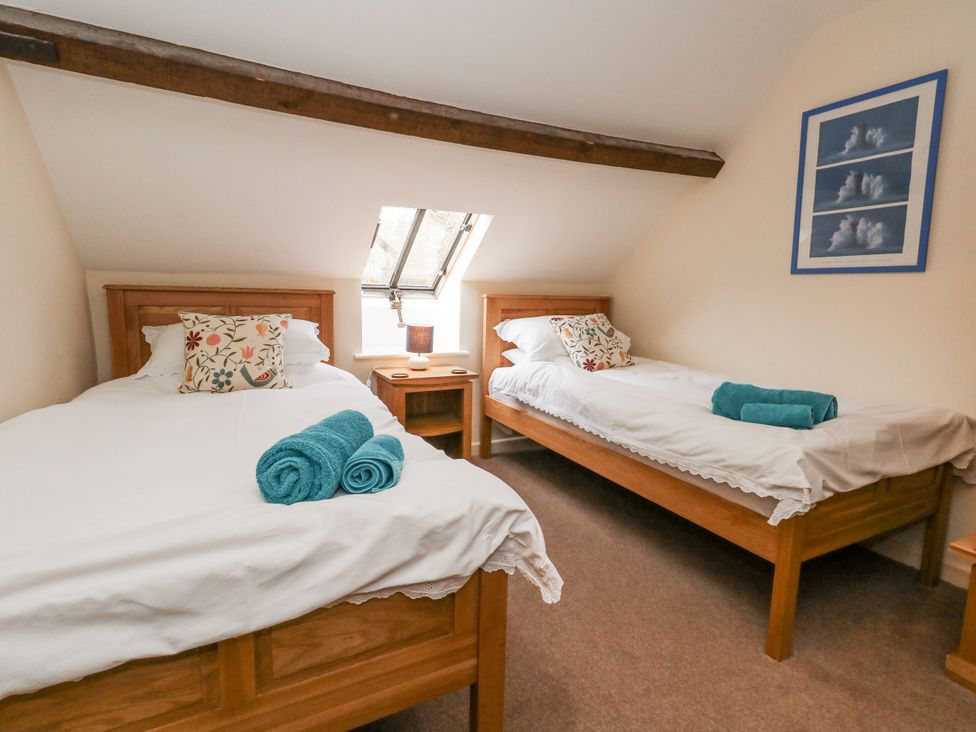 A bedroom with two single beds and a window at Droop Farm Cottage Droop near Hazelbury Bryan