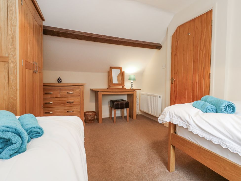 A bedroom with two beds and a dresser at Droop Farm Cottage in Droop near Hazelbury Bryan