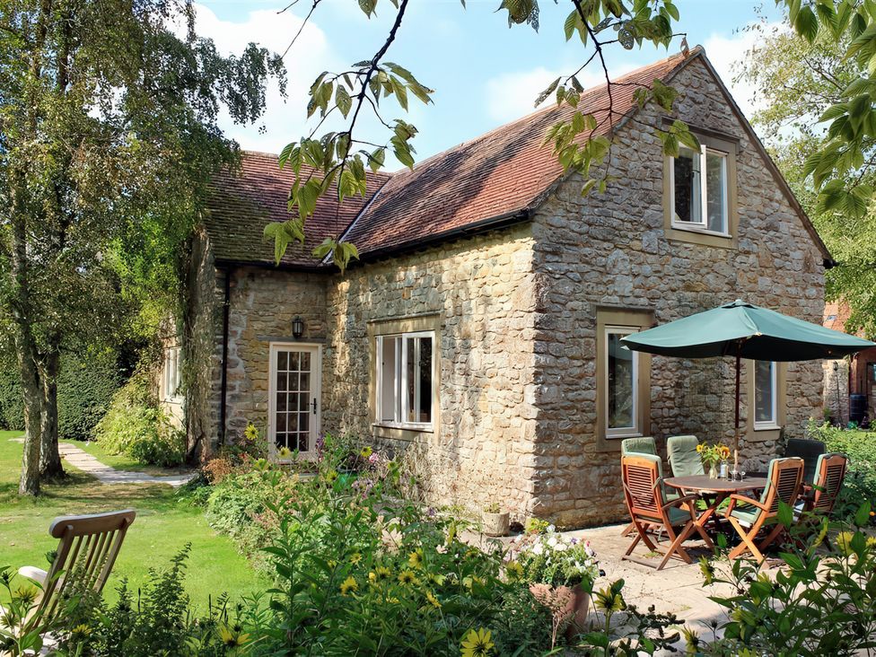 A cottage with a patio and garden at Droop Farm Cottage in Droop near Hazelbury Bryan