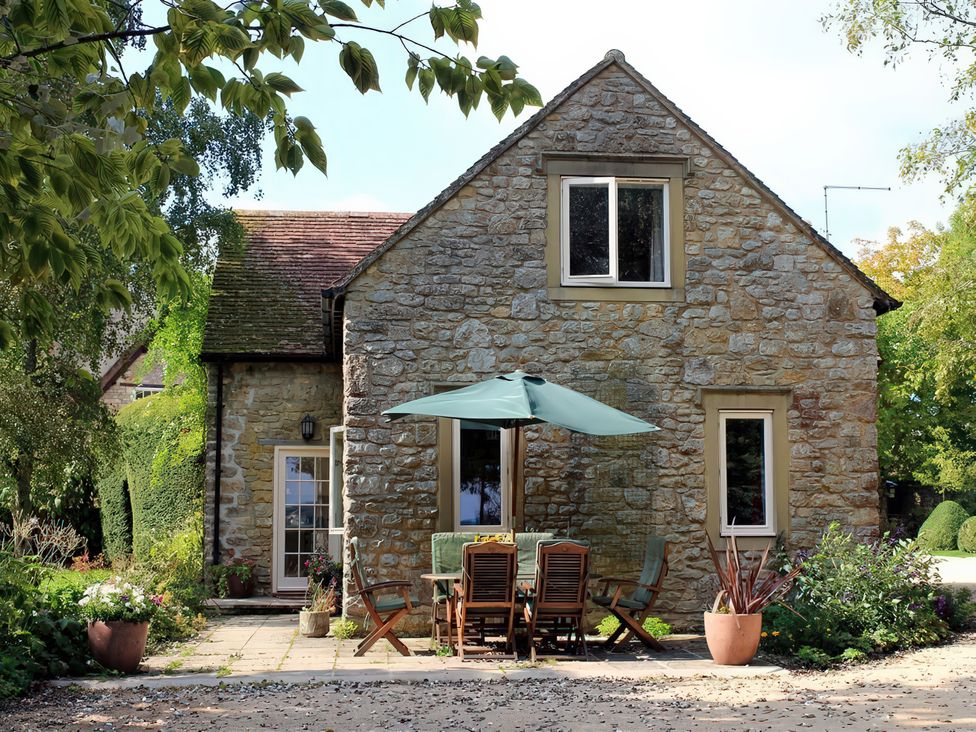 A stone house with outdoor seating at Droop Farm Cottage Droop near Hazelbury Bryan