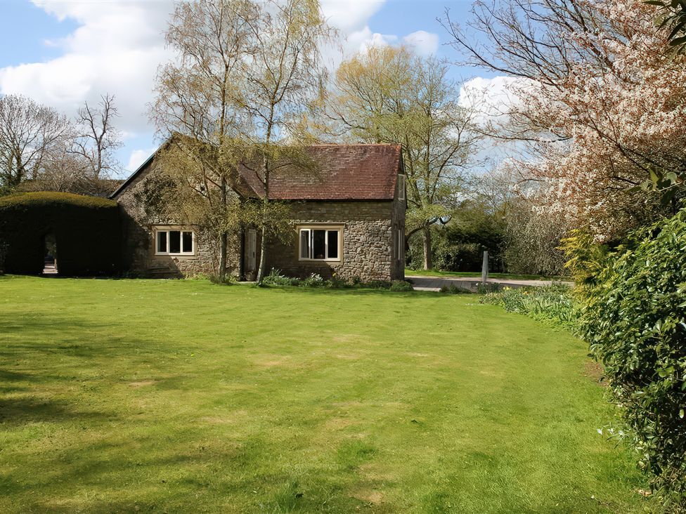 A house with a lawn and trees at Droop Farm Cottage in Droop near Hazelbury Bryan