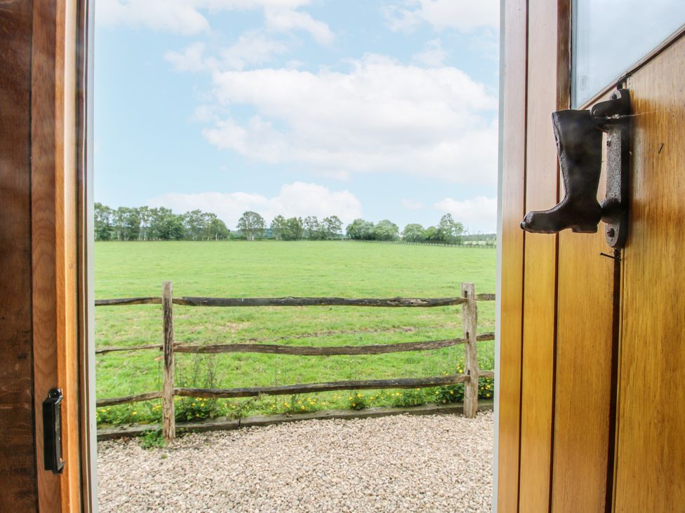 A view from a door showing a field and fence at The Shooting Folly in Cheswardine
