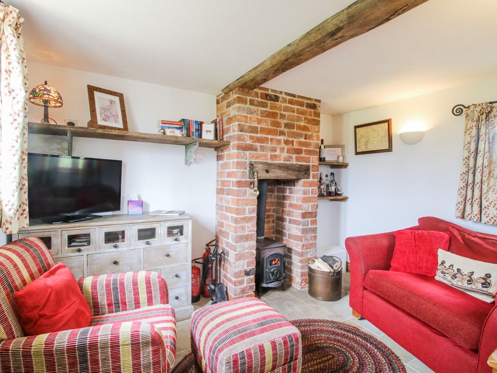 A living room with a fireplace and seating area at The Shooting Folly in Cheswardine
