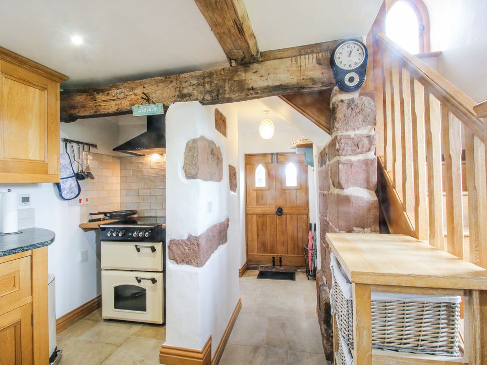A kitchen with an oven and staircase at The Shooting Folly in Cheswardine