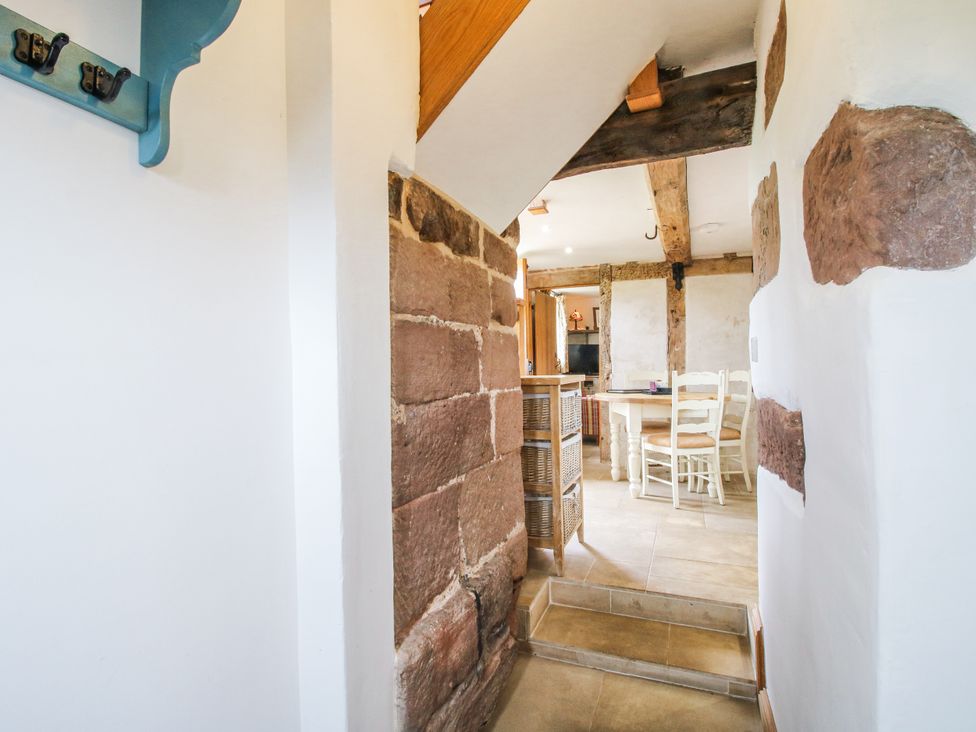 A hallway with coat hooks and stairs leading to a dining area at The Shooting Folly in Cheswardine