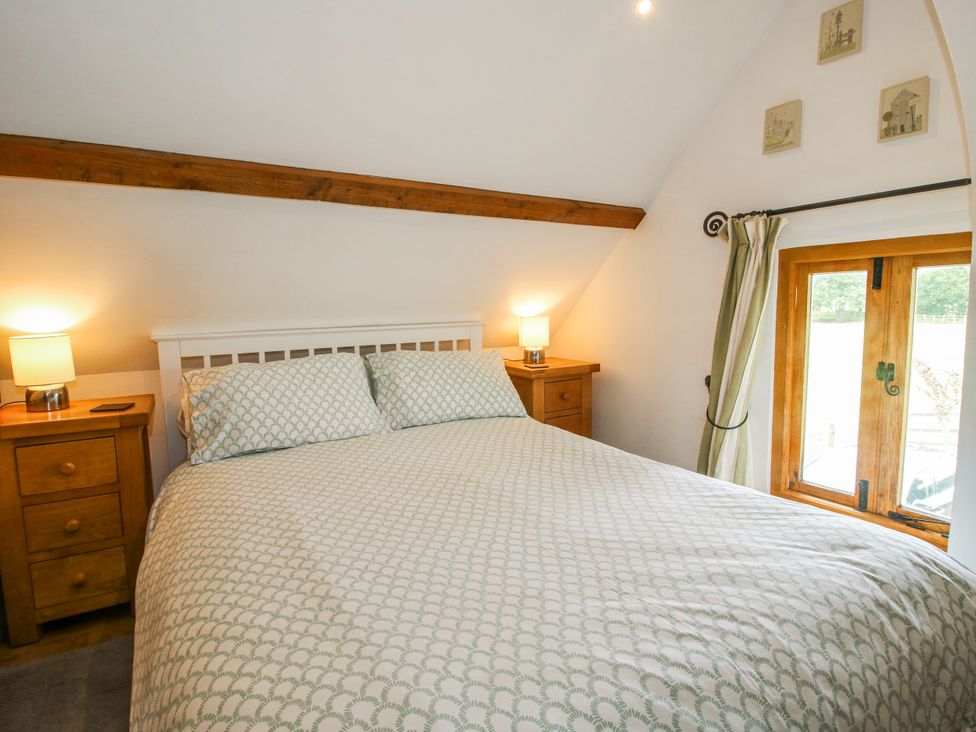 A bedroom with a bed and nightstands at The Shooting Folly in Cheswardine