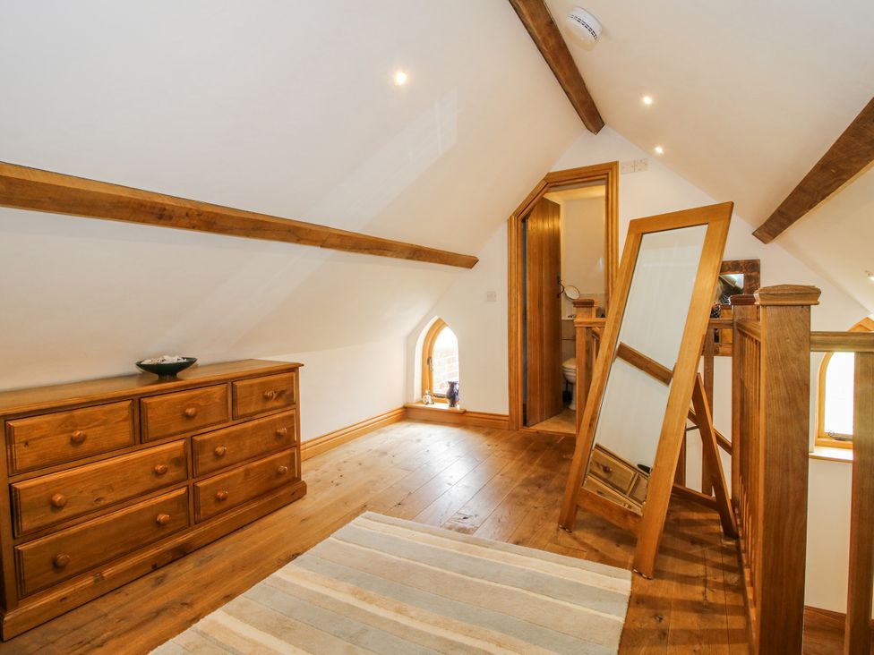 A loft space with a dresser and mirror at The Shooting Folly in Cheswardine