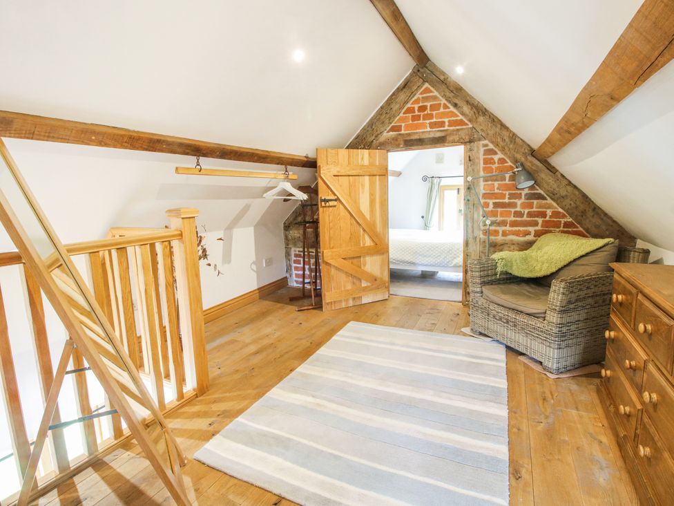 A loft area with a chair and dresser at The Shooting Folly in Cheswardine