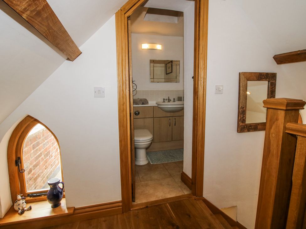 A staircase leading to a bathroom with a sink and toilet at The Shooting Folly in Cheswardine