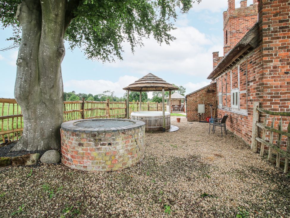 A courtyard with a gazebo and hot tub at The Shooting Folly in Cheswardine