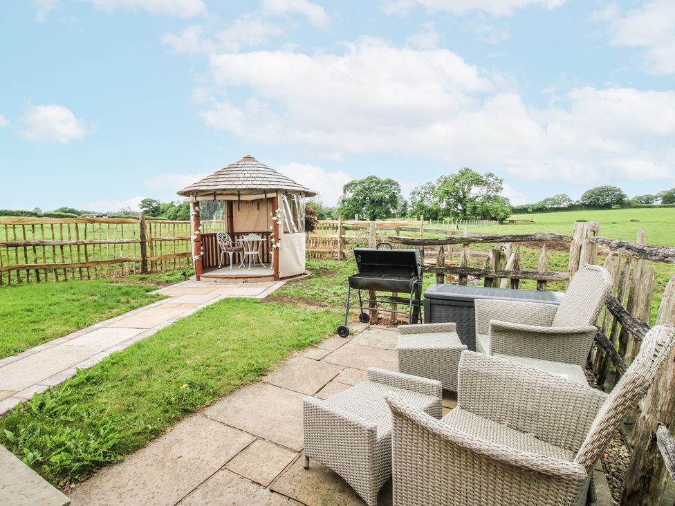 A garden with a gazebo and seating area at The Shooting Folly in Cheswardine