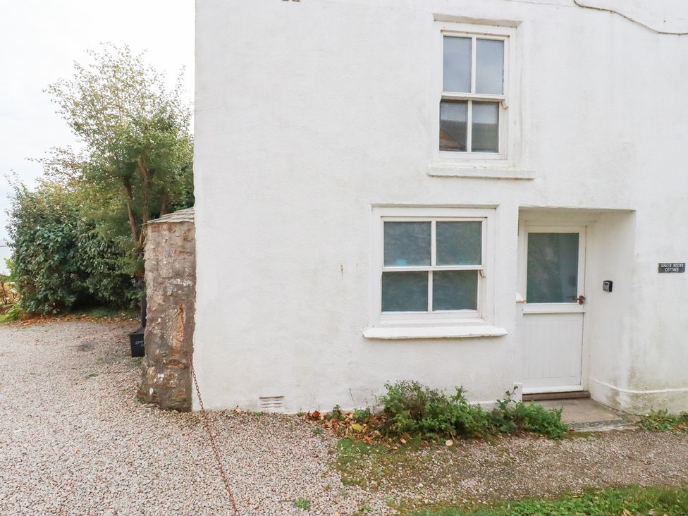 An exterior view of a white cottage with windows and door at Greeb Rocks Cottage Marazion