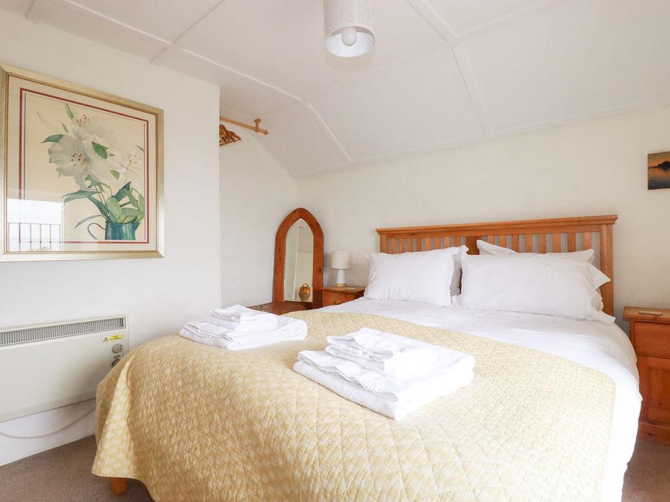 A bedroom with a bed and bedside furniture at Greeb Rocks Cottage Marazion