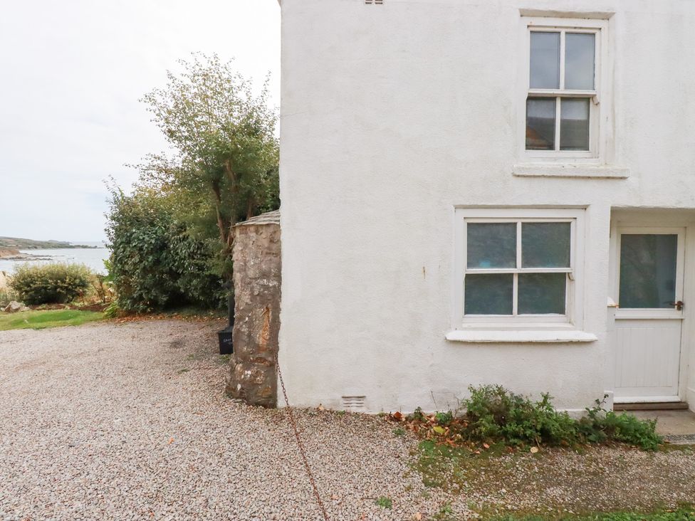 An outdoor view of a house with gravel driveway at Greeb Rocks Cottage in Marazion