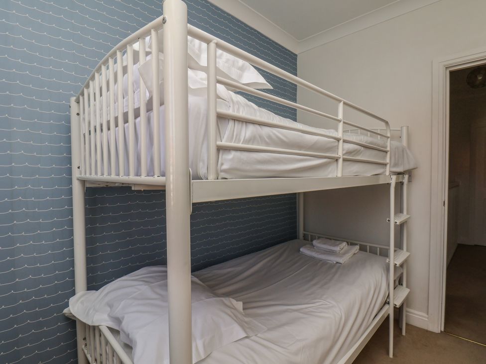 A bedroom with a bunk bed and sheets at Haven House in Whitby