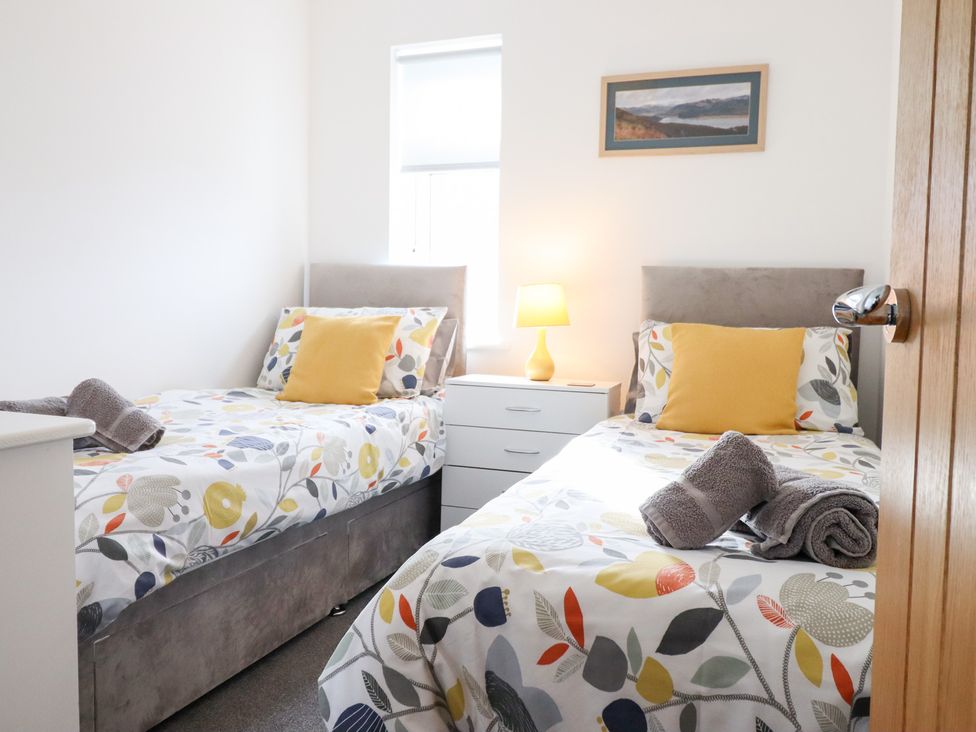 A bedroom with two beds and a lamp at Arnant in Dolgellau