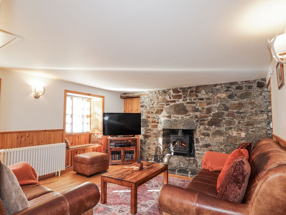 A living room with a fireplace and a television at 83 Seatown in Cullen