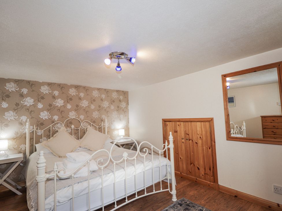 A bedroom with a bed and nightstand at 83 Seatown, Cullen