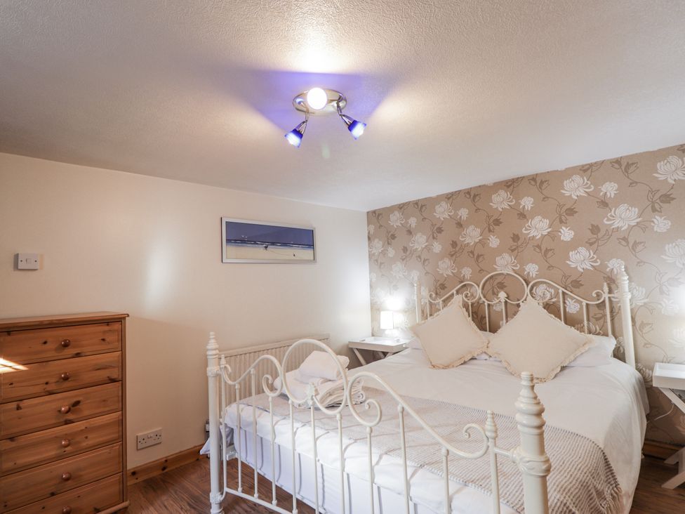 A bedroom with a bed and wooden furniture at 83 Seatown, Cullen