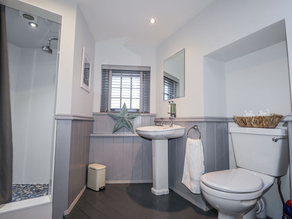 A bathroom with a shower, sink, and toilet at 83 Seatown, Cullen