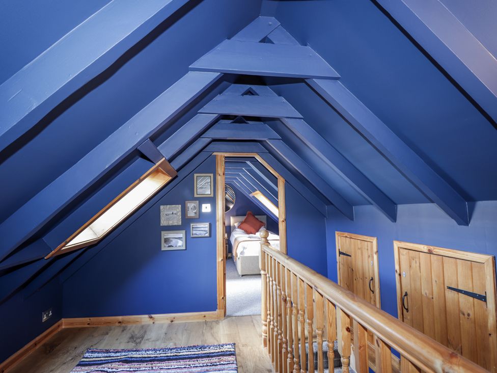 A hallway with wooden railing and framed pictures at 83 Seatown, Cullen