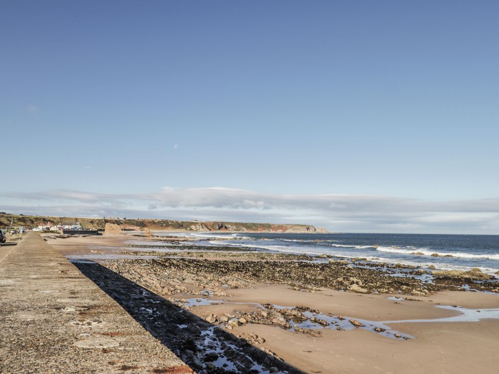 A beach with rocks and vehicles at 83 Seatown in Cullen