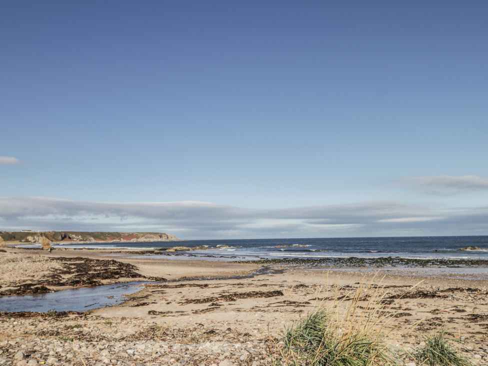 A beach with sand and ocean at 83 Seatown, Cullen