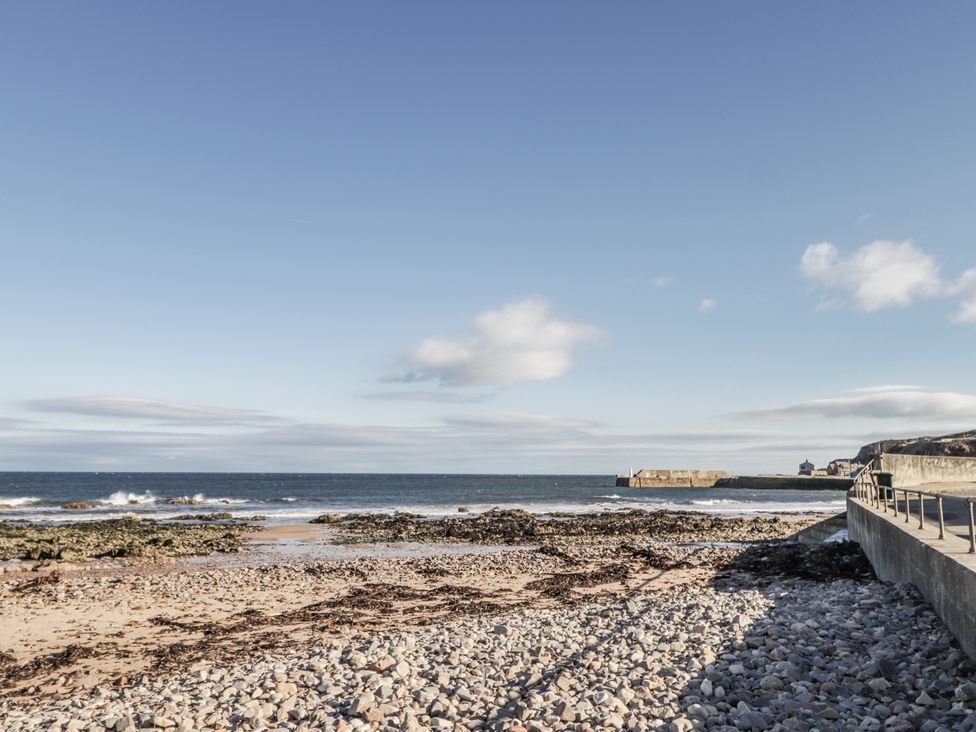A beach with rocks and seaweed near the ocean at 83 Seatown, Cullen