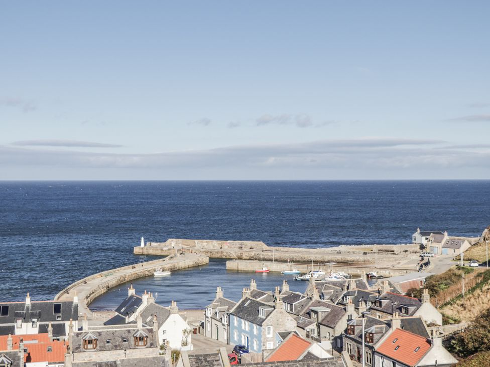 A view of the harbor with boats and houses at 83 Seatown in Cullen